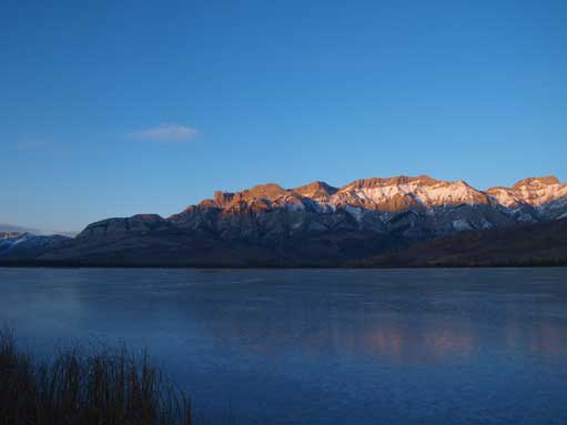Miette Range rises behind the frozen Talbot Lake.