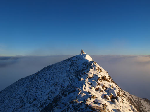 The true summit is within touching range.