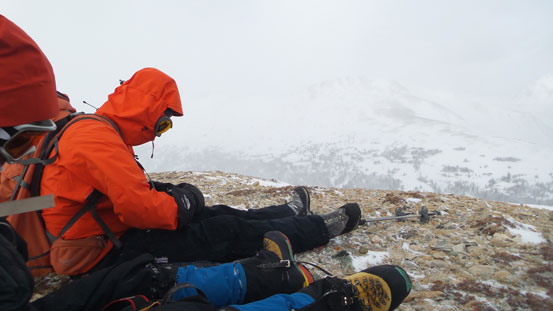 Sitting on the summit in order not to be blown off.