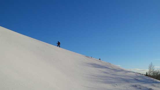 Grant snowshoeing up a snow ridge