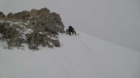Down climbing steep snow to bypass the rock step on the lower ridge
