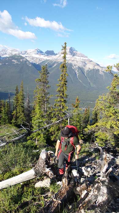 Brandon scrambling up the lower treed ridge