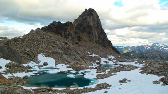 Eastpost Spire rises behind some tarns