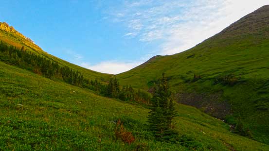 Ahead is the first (grassy) col - note the foreshortening view