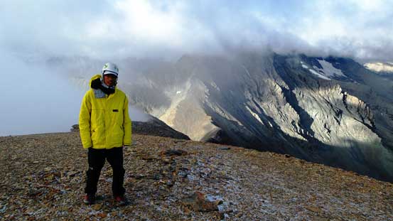 Me on the summit with Mt. Harrison in the background hidden in clouds
