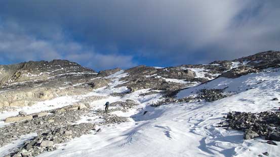 Eric hiking up a mix of snow drifts and the dry rock.