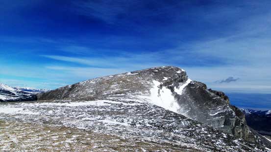 The broad summit ridge isn't as easy as it looks in the gusting wind.