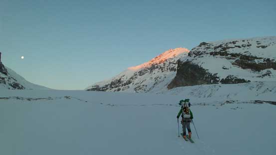 Vern approaching the toe of Athabasca Glacier, with alpenglow on Snow Dome behind