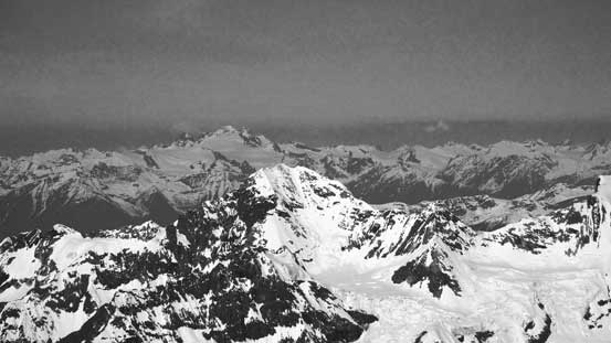 The Adament Group rises behind the summit of Rostrum Peak
