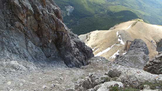 Looking down the scree bowl. It also shows the key (exposed) ledge traverse linking the bowl and the lower face