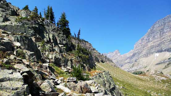 Contouring towards climber's left on a grassy ledge
