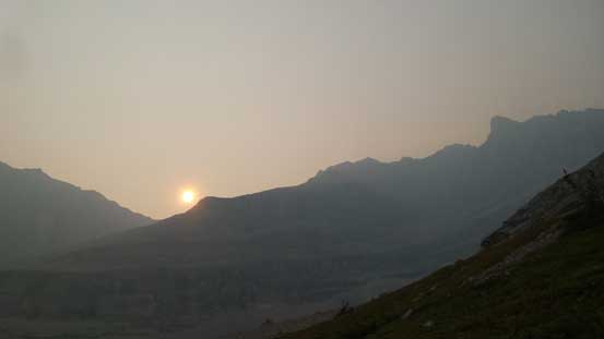The smoky sun behind the shoulder of Elpoca Mountain