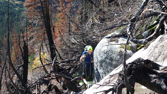 Ben squeezing between the deadfalls and the boulder