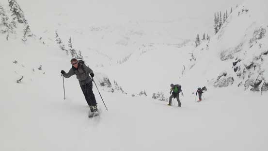 Skinning up this steep gully to break another cliff band