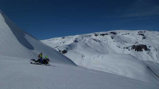 One of the many snowmobiles with the dome shaped Powder Mountain behind
